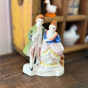 Vintage hand-painted porcelain figurine of a colonial or Victorian couple.
